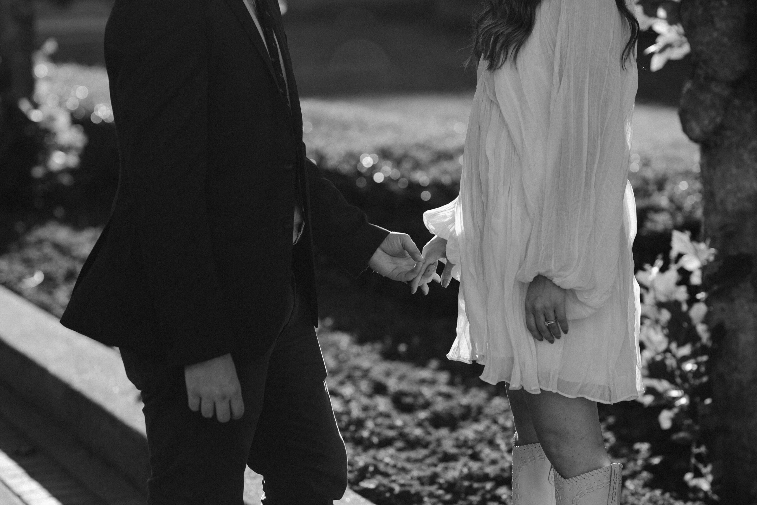 black and white detail photo of bride and groom holding hands outside of san francisco city hall