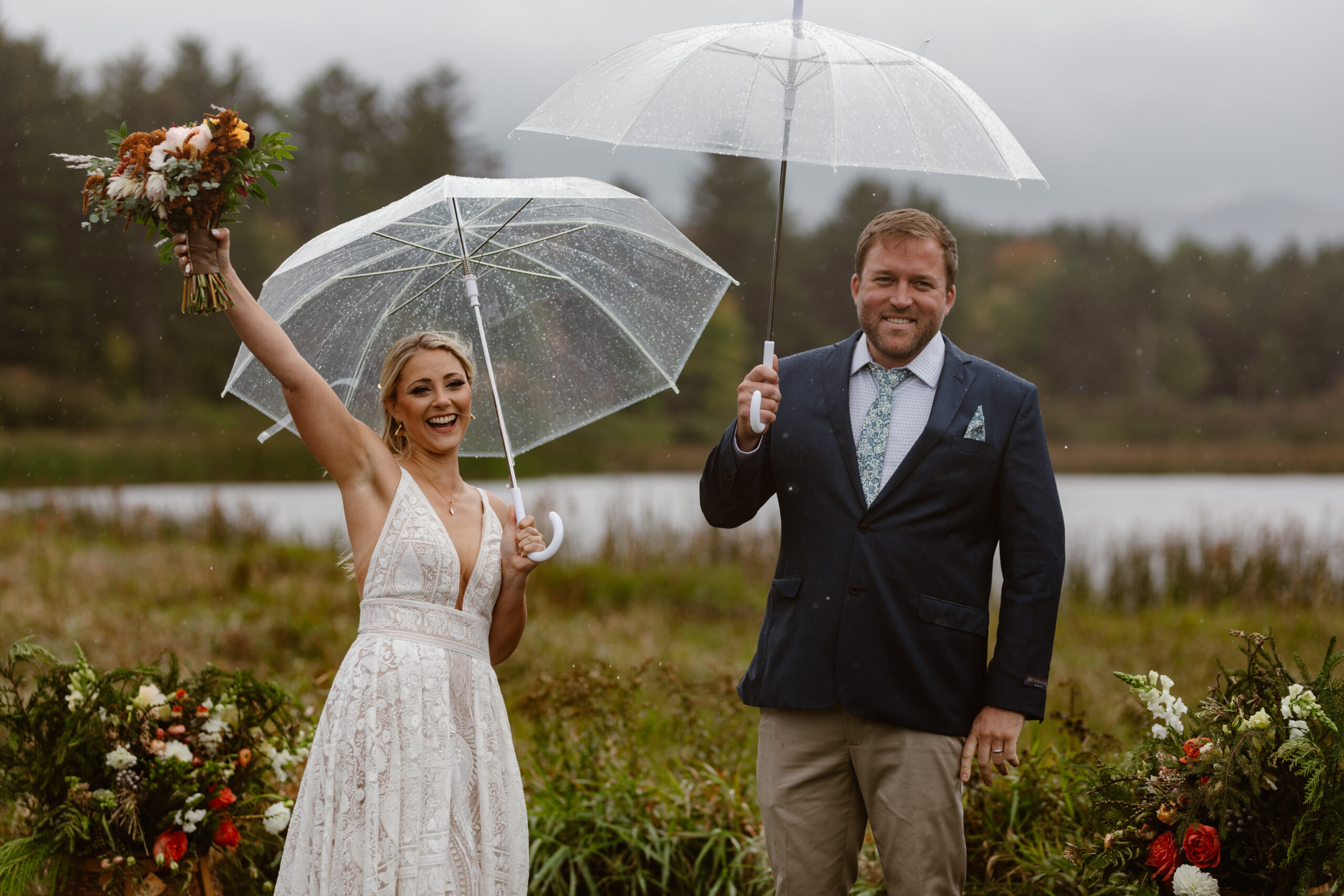 bride and groom cheering with umbrellas during their lake placid elopement ceremony