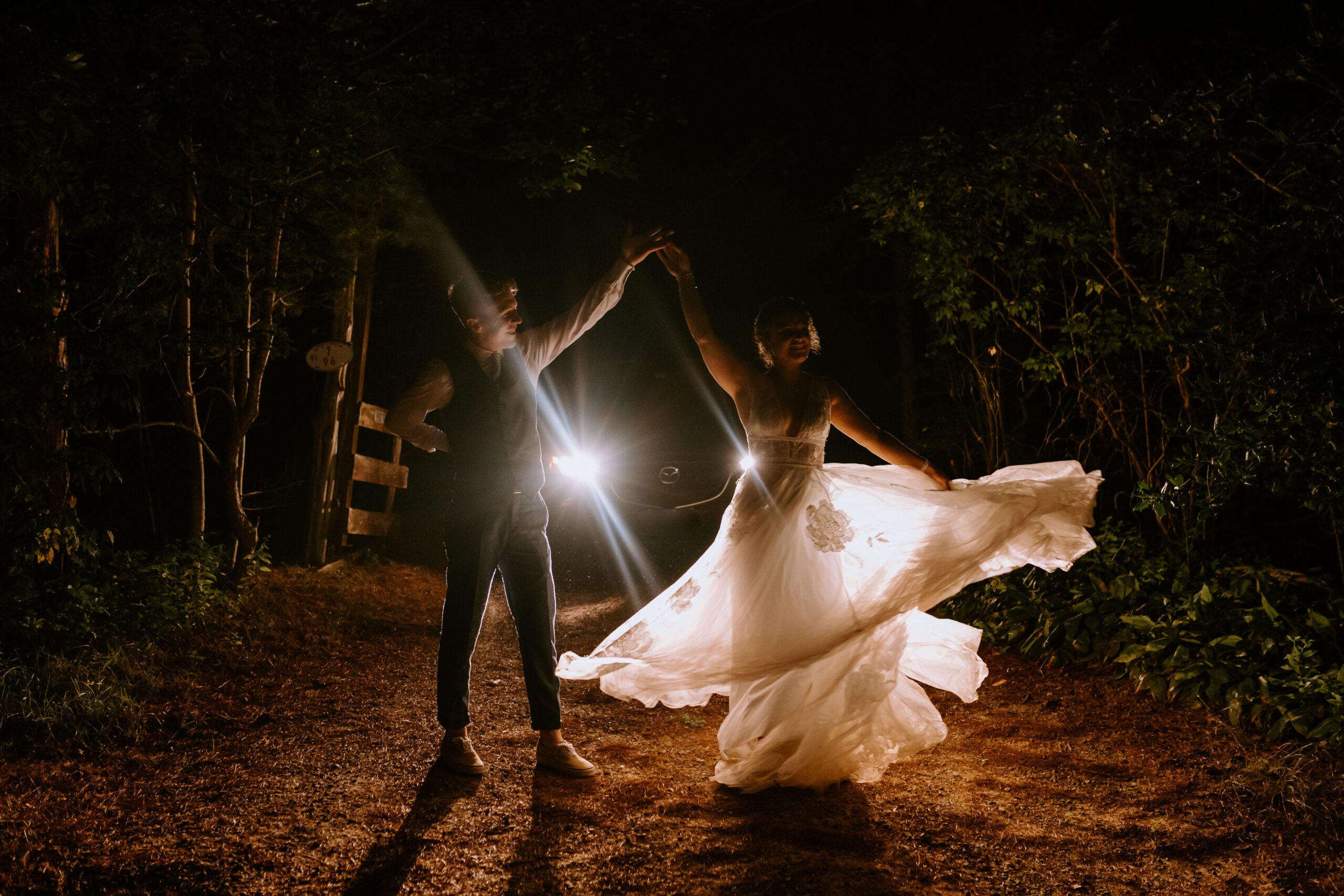 bride and groom dancing in the light of the car's headlights at the end of their martha's vineyard elopement